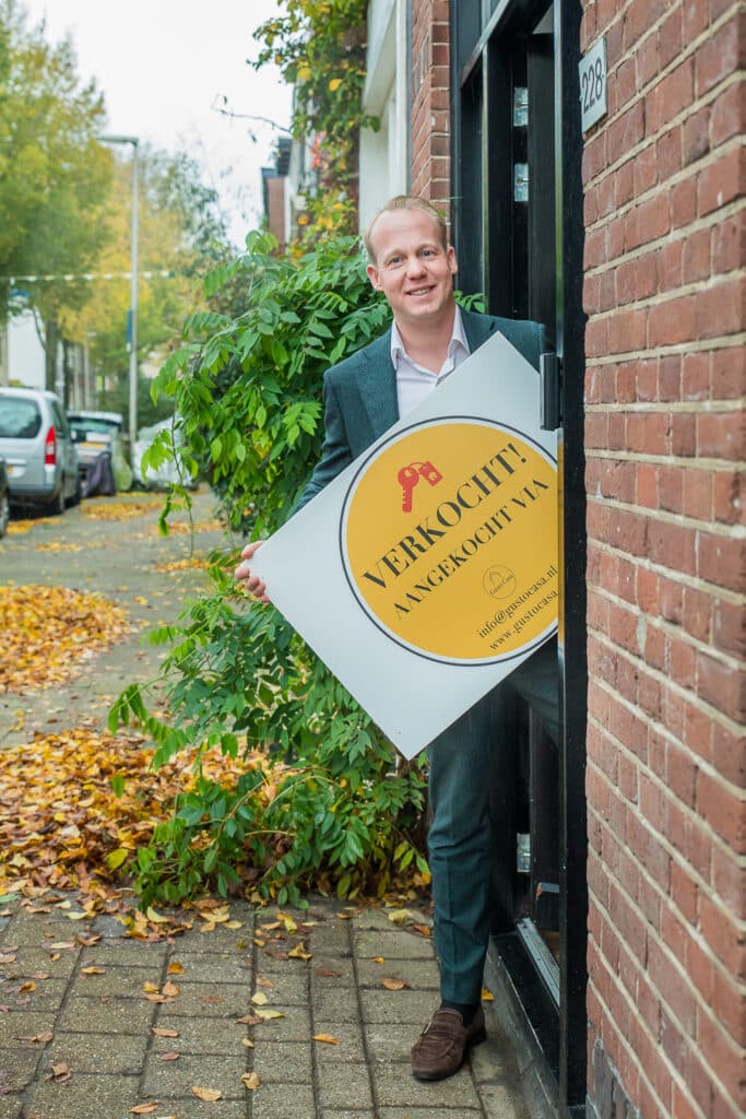 Gé Hoeijmakers met een te koop bord